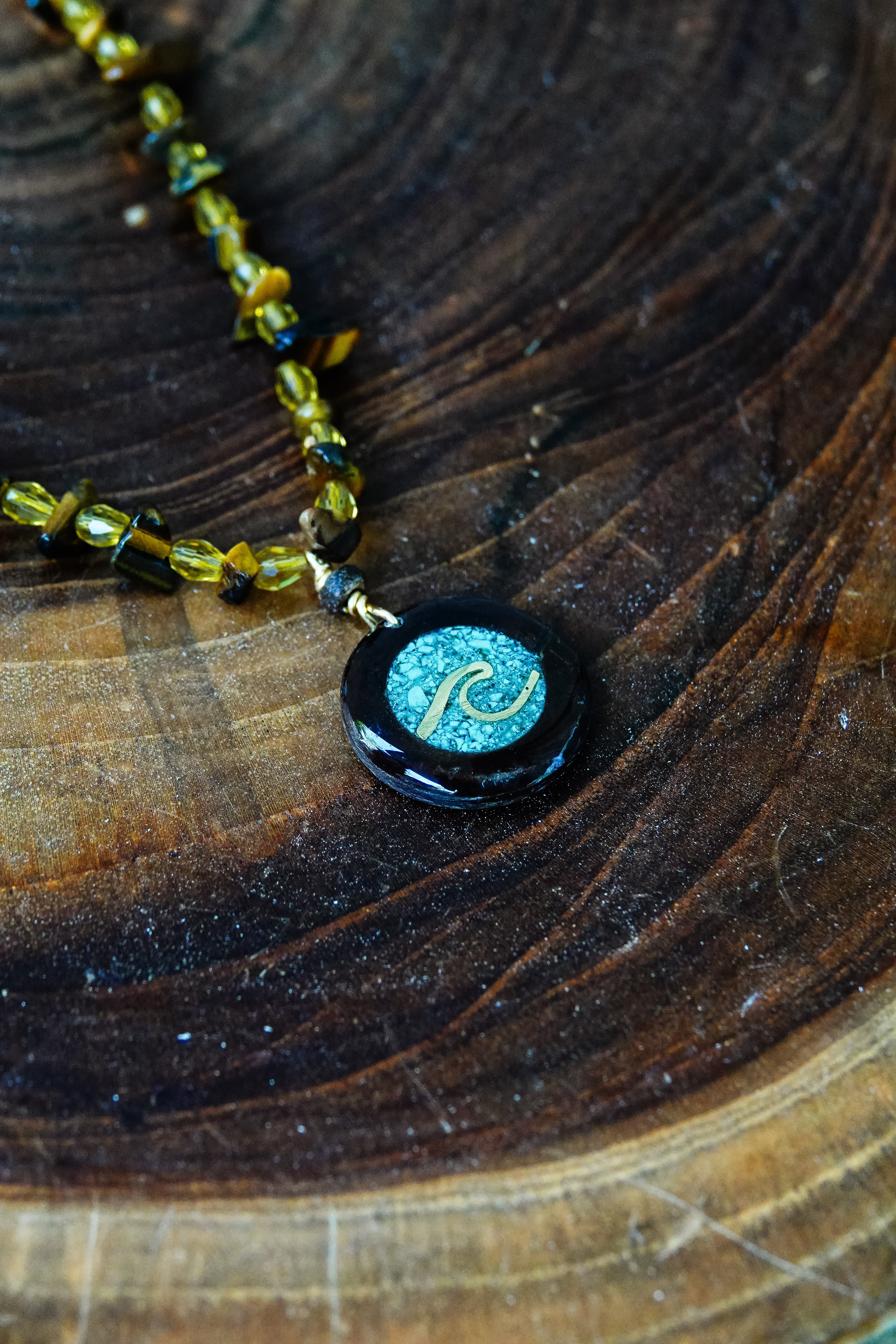 Necklace with a black pendant featuring a blue wave