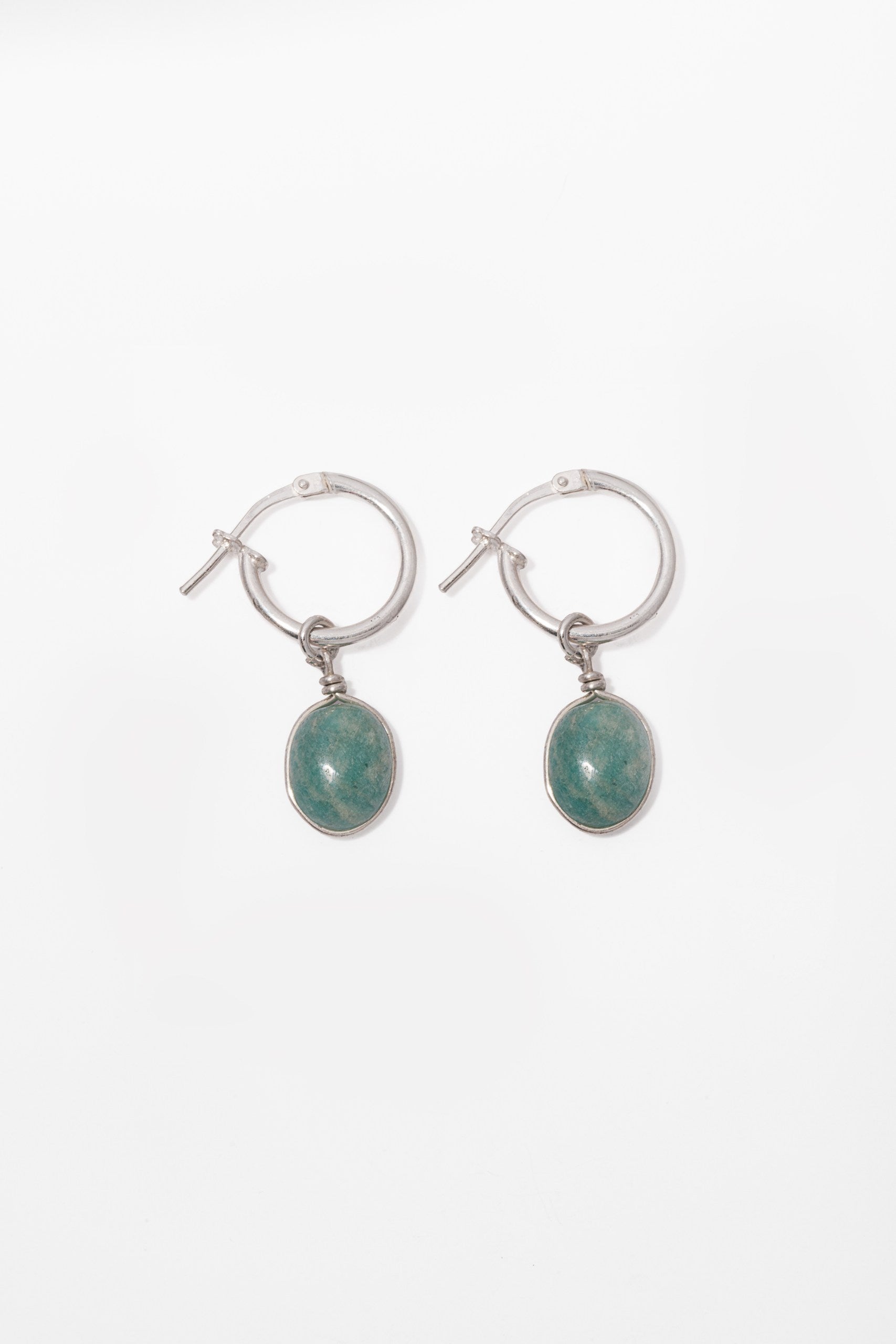 A pair of silver hoop earrings with Amazonite stone oval green gemstone drops, shown on a plain white background.