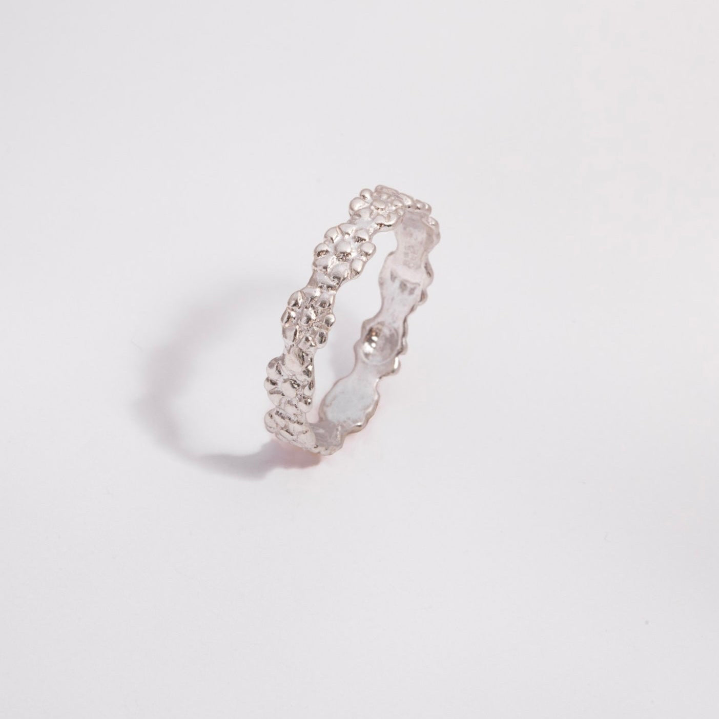 Silver ring on a light gray background