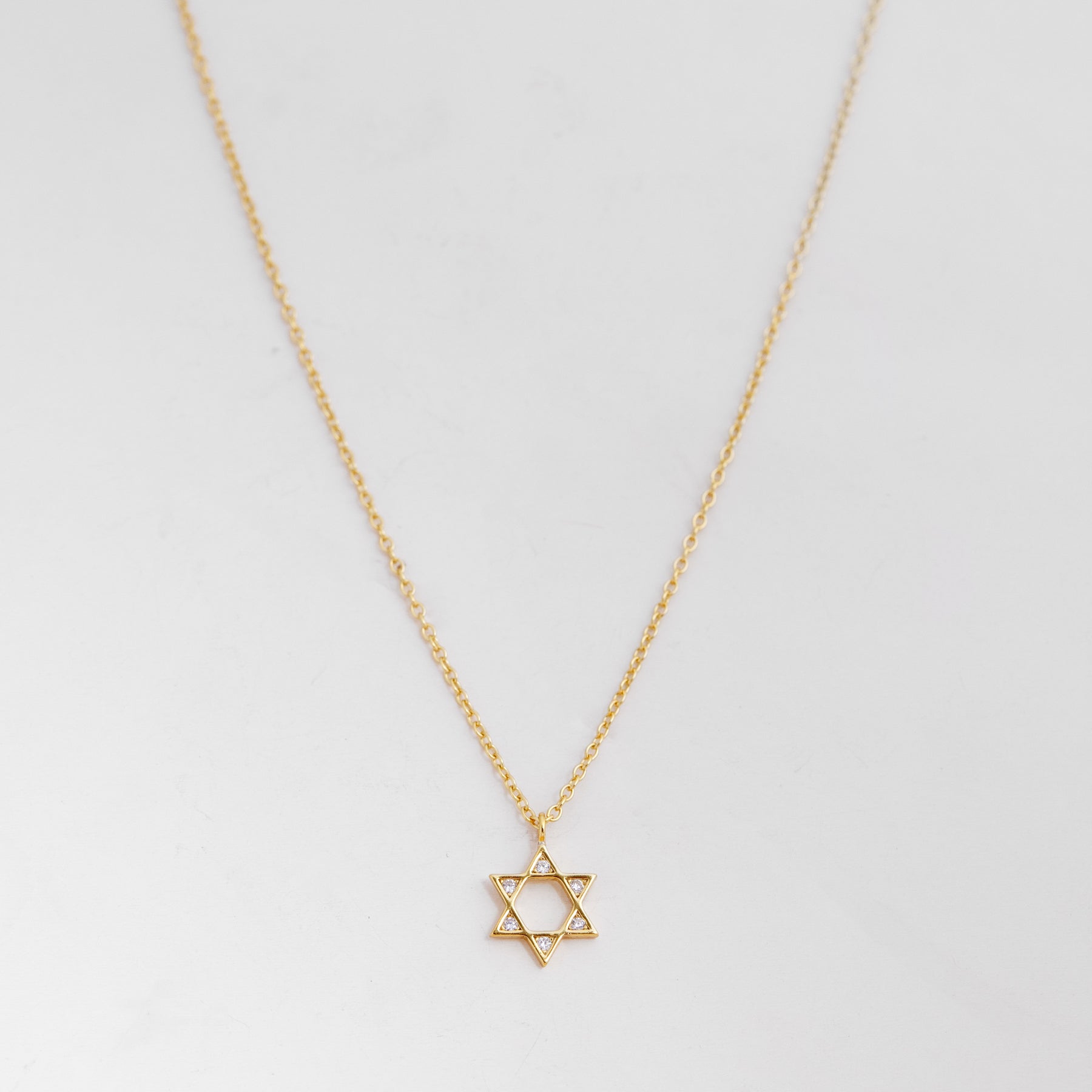Tiny Star of David necklace with sparkling CZ crystals, crafted in waterproof gold vermeil with a delicate gold chain.