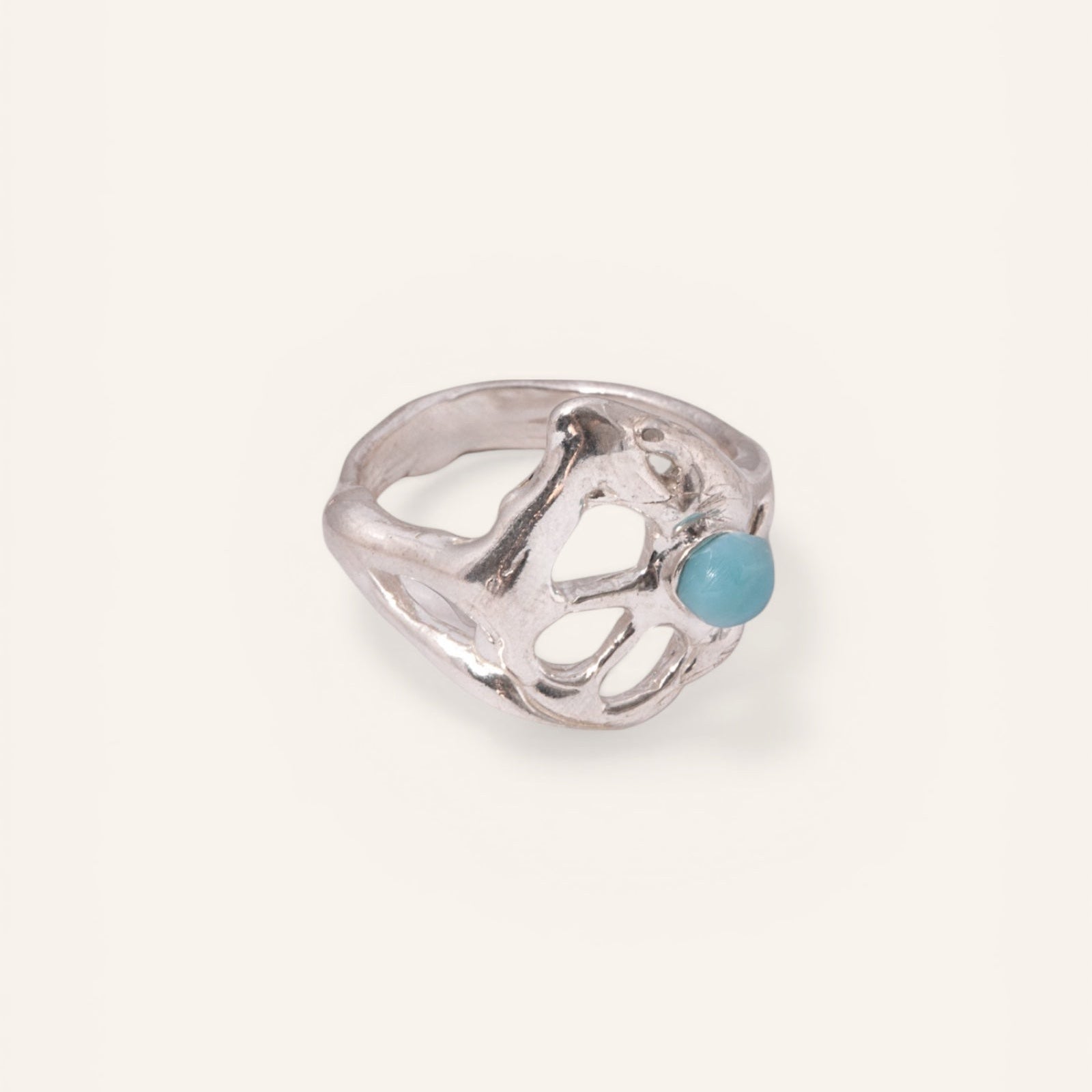 Silver ring with a blue gemstone on a white background